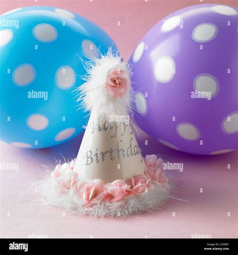 Balloons and a party hat Stock Photo - Alamy