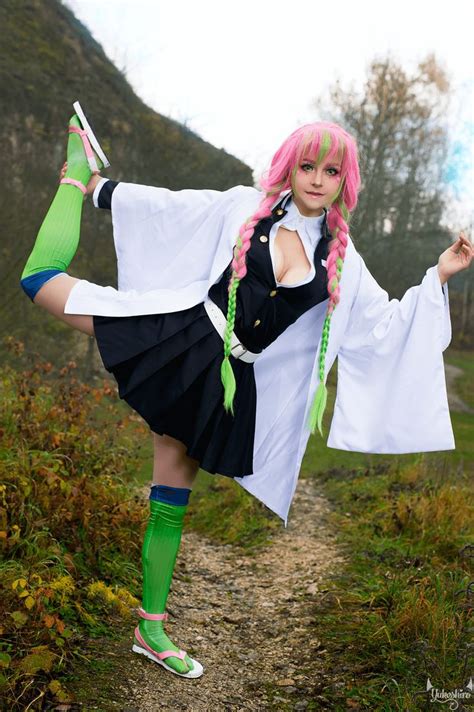 a woman with pink hair and green socks is posing on a path in the woods