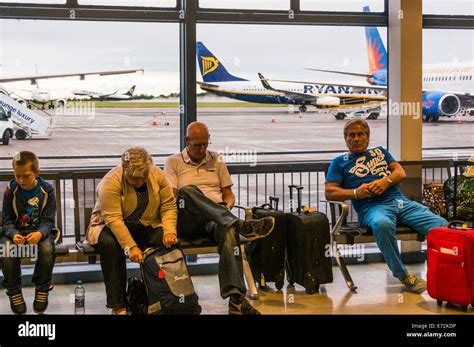 People waiting in the departures lounge at East Midlands Airport with a Ryanair Boeing 737 ...