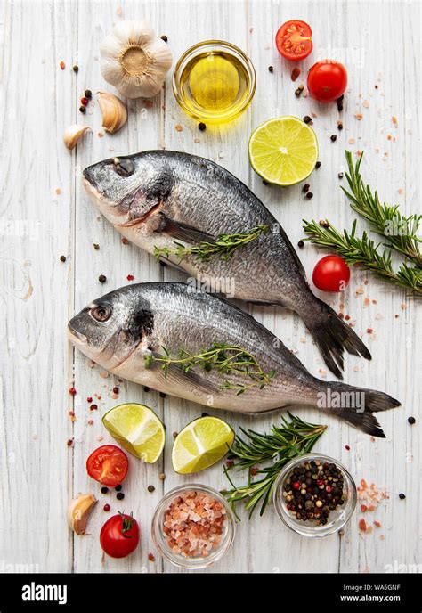 Fresh fish dorado. Dorado and ingredients for cooking on a table Stock Photo - Alamy