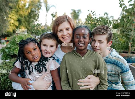 Smiling mid-40's mom & and four happy children- mixed race family Stock Photo - Alamy