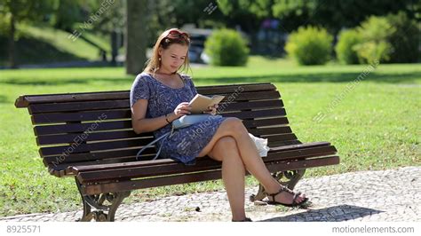 Young Woman Reading A Book And Sitting On A Bench Outside In A Park In Summer, B Stock video ...