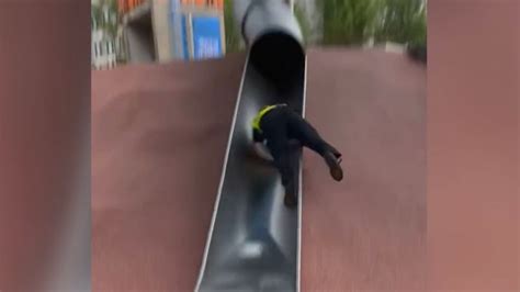 Boston police officer catapults off playground slide in viral video | CNN