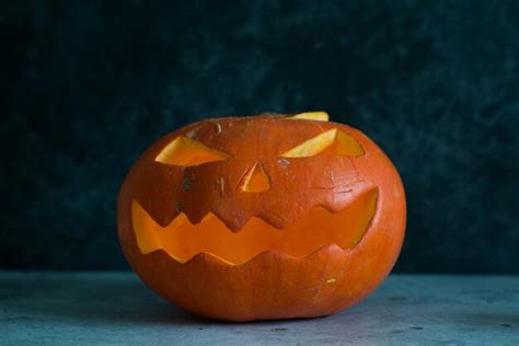 Premium Photo | A carving pumpkin with candles on gray background