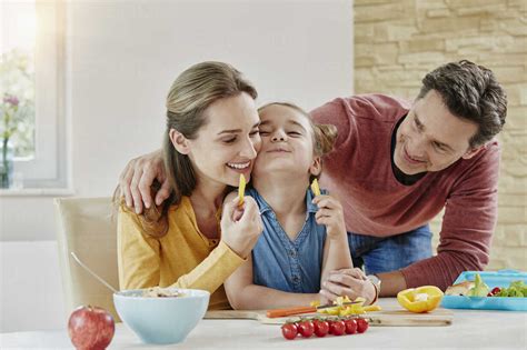 Happy family at home preparing healthy food stock photo