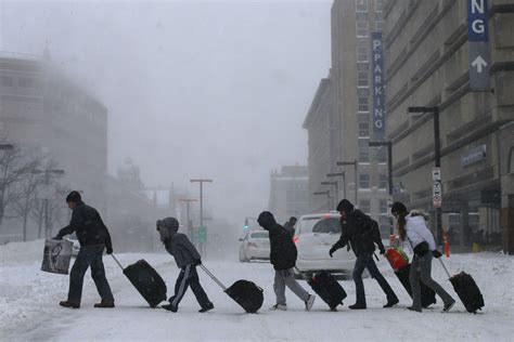 Travelers leave Back Bay train and subway station during winter nor’easter snow storm in Boston