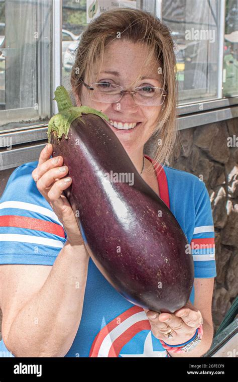 A woman holding a very large eggplant Stock Photo - Alamy