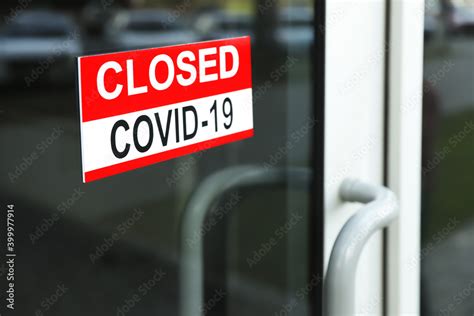 Red sign with words "Closed Covid-19" hanging on glass door Stock Photo ...