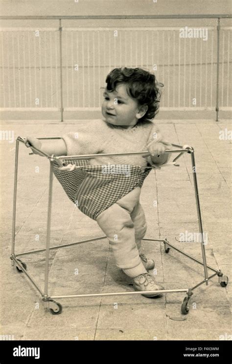 A baby takes its first steps aided by a walker, Italy Stock Photo - Alamy