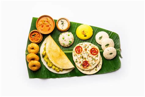 South Indian Masala Dosa, Uttapam, Idli vada sambar, semolina halwa, upma served over banana ...