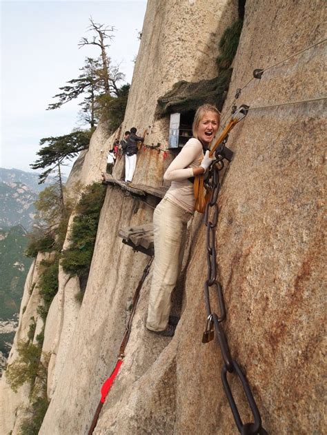 a woman climbing up the side of a mountain