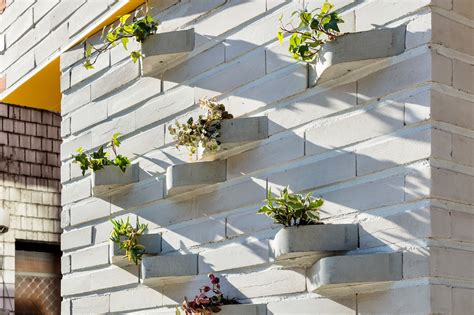 Creative brick design with a built-in planter turns the outer facade of this house into a ...