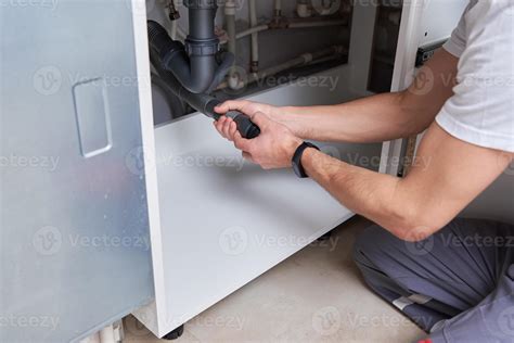 Male plumber repair sink pipe in kitchen 13052402 Stock Photo at Vecteezy