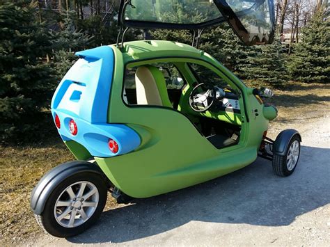 sam is a bug-eyed three-wheeled two-person electric vehicle