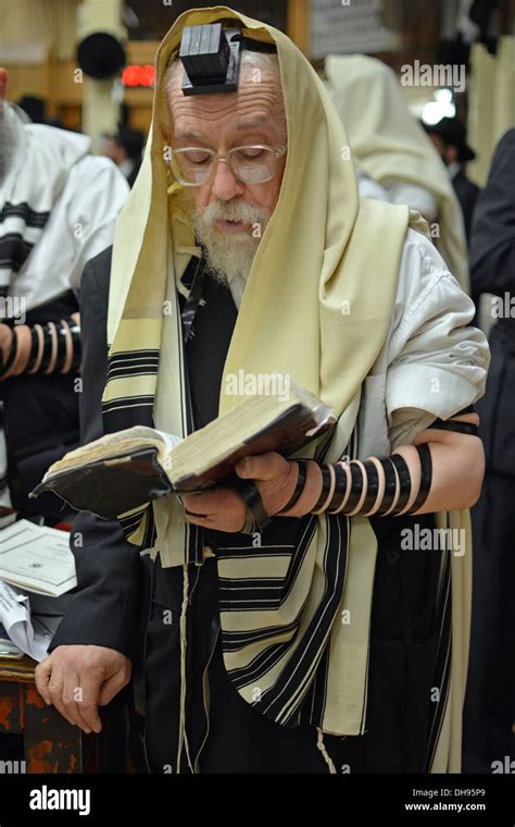 Religious Jewish man praying wearing Tefillin, phylacteries, and a prayer shawl at Lubavitch ...