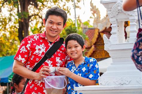 Thai family participate old traditional activity in a temple during Songkran festival in Chiang ...