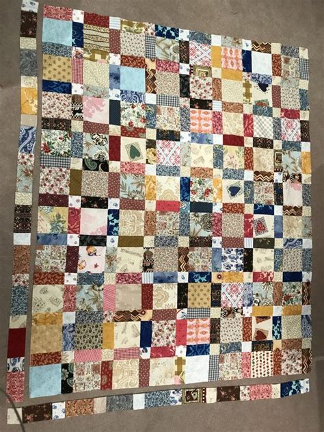 an old patchwork quilt hanging on the wall