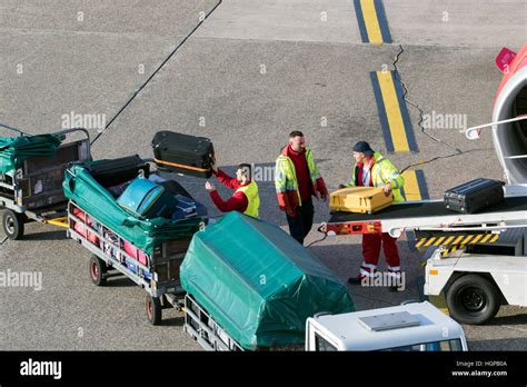 Baggage handlers unloading luggage from an airplane at Dusseldorf airport Stock Photo - Alamy