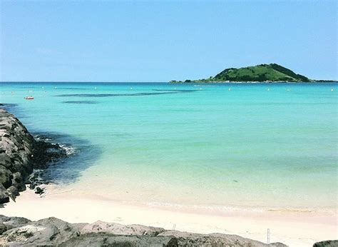 the beach is clear and blue with small boats in the water