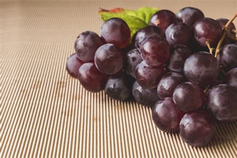 Premium Photo | Close up of red grapes on wooden table