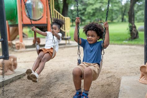 Happy African American little boy and girl have fun at the playground ...