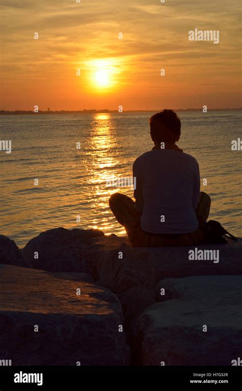 person on the cliff at sunset Stock Photo - Alamy