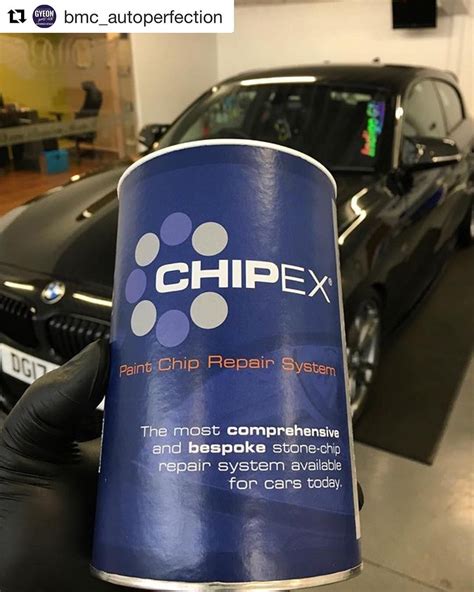 a can of chippex next to a black car in a showroom with other cars