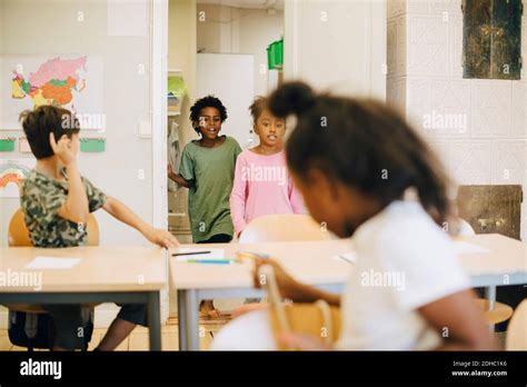 Excited students entering in classroom at elementary school Stock Photo ...