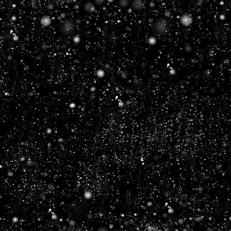 black and white photograph of snow flakes on the dark background with ...