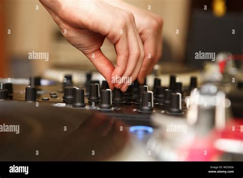 Professional hip hop dj mixes tracks on sound mixer controller in night ...