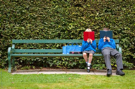 «Two Children In School Uniform Reading Books On A Park Bench» del ...
