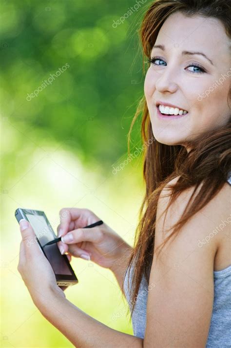 Young smiling brunette woman holding smartphone and stylus Stock Photo by ©BestPhotoStudio 6554594