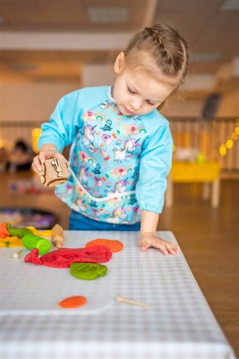 A Little Girl Playing with Plasticine. Sensory Development and Experiences, Themed Activities ...