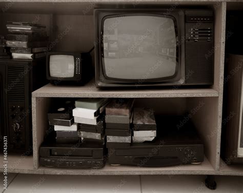 Old video recorder and tv . Vintage Video VHS Player on the shelf. VHS cassette and DVD disc ...