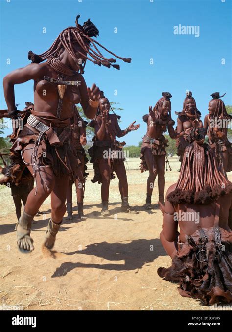 Namibia, Kaokoland. Himba women perform the otjiunda dance, stamping ...