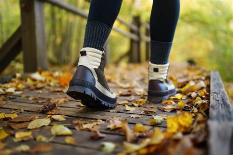 Premium Photo | Women's feet in boots go along a wooden walking path in ...