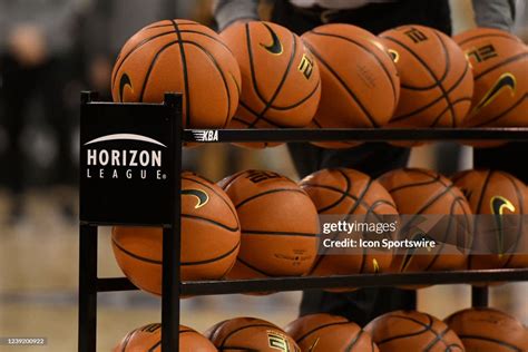 A Horizon League logo is seen on the side of a cart of basketballs ...