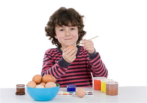 Premium Photo | Child adorable adorning easter eggs on a white background