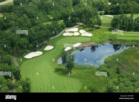 Aerial view of golf course fairway and green with sand traps, pond and trees Stock Photo - Alamy