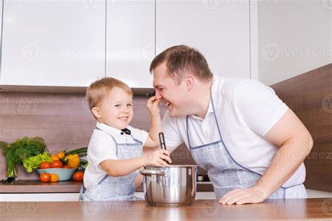 Dad and son cooking together in the kitchen preparing food, having fun at home 12973002 Stock ...