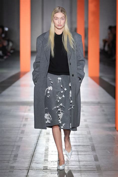 Jupe brodée et manteau gris aperçus sur le défilé Prada