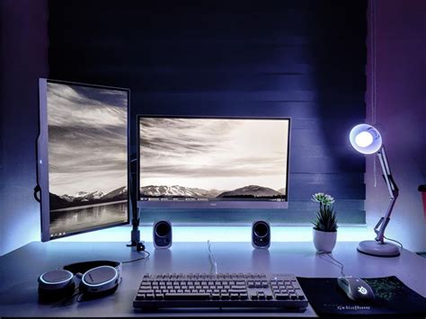 two computer monitors sitting on top of a desk in front of a keyboard ...