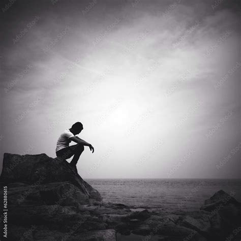 man sitting alone on the beach Stock Photo | Adobe Stock