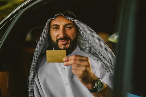 Premium Photo | Rich man An arabian man in a traditional clothing in a car holding a credit card