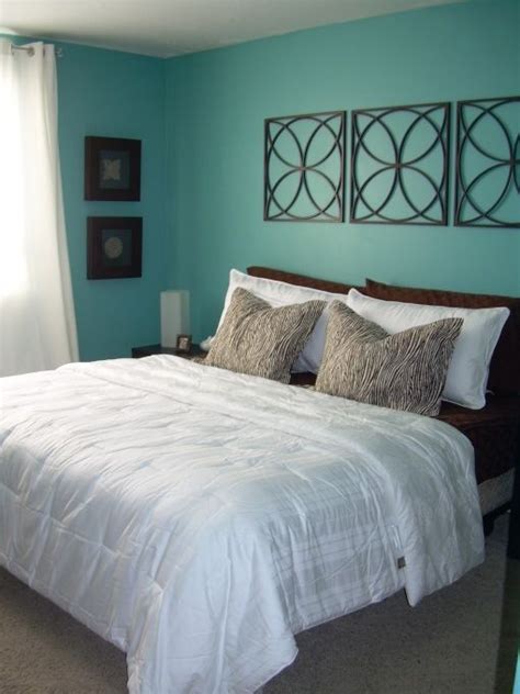 a bedroom with blue walls and white bedding