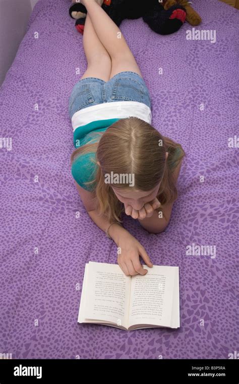 Young Girl lying on bed sur son ventre la lecture d'un livre Photo ...