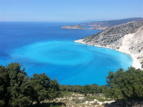 the blue water is surrounded by trees and hills