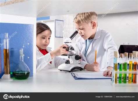 Kids using microscope Stock Photo by ©NatashaFedorova 139845384