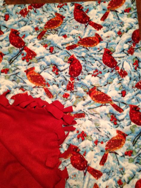 a red and white blanket with birds on it