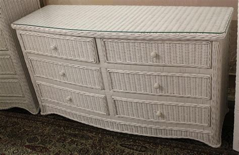 a white wicker dresser with glass top